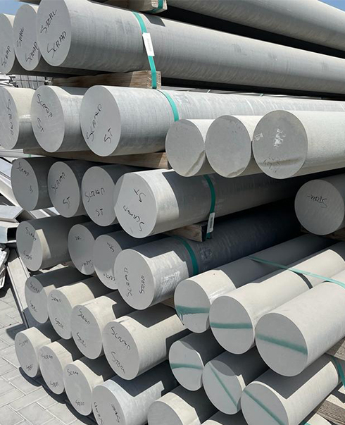 Stacked aluminium rods in a scrap yard